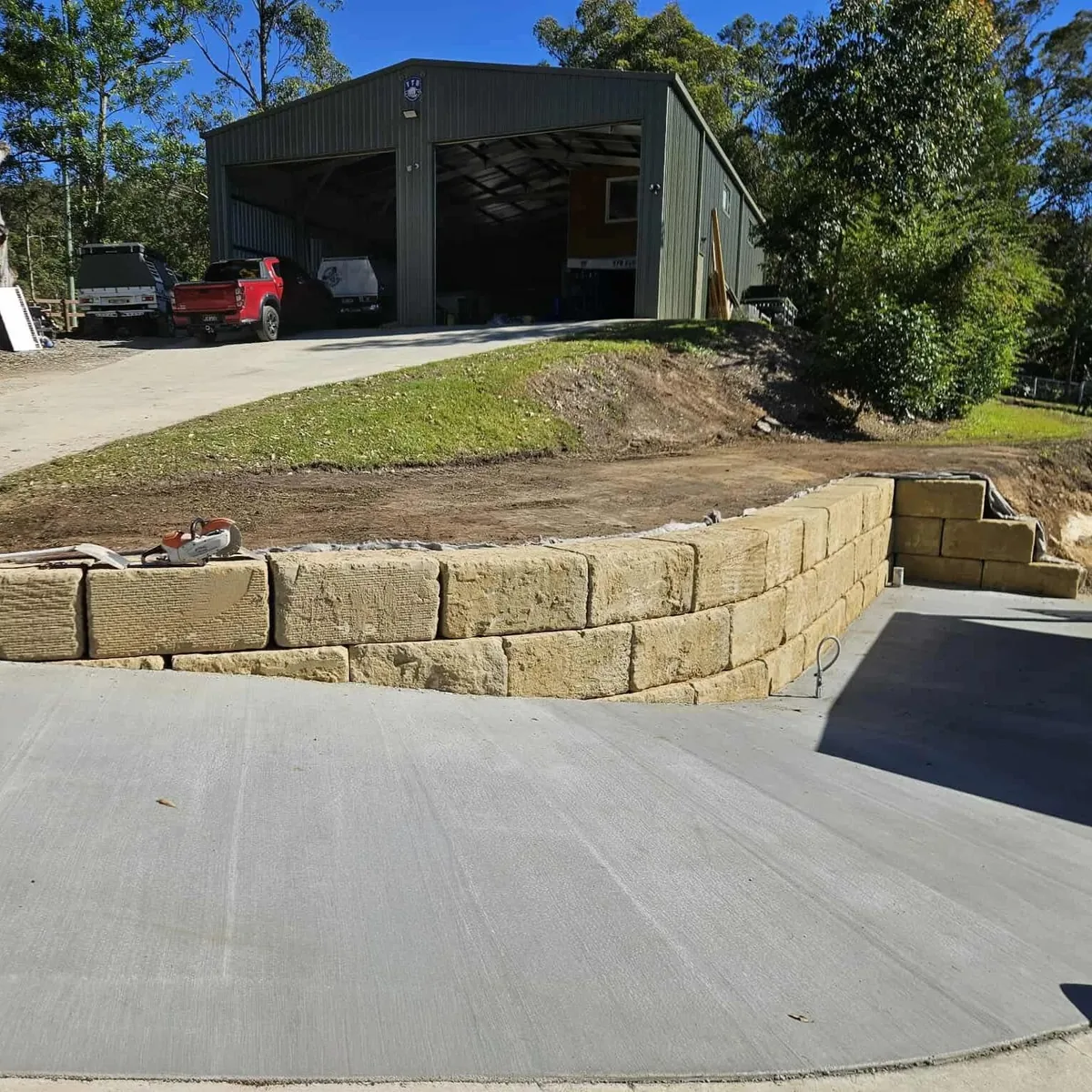 Concrete driveway and sandstone retaining wall on a rural shed site